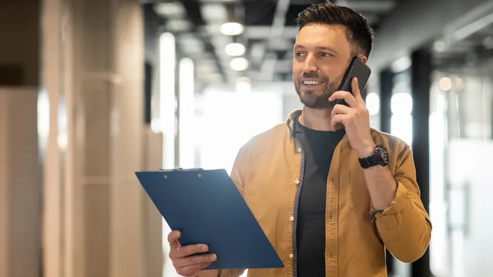 Imagem ilustrativa de empreendedor ligando por telefone com prancheta na mão